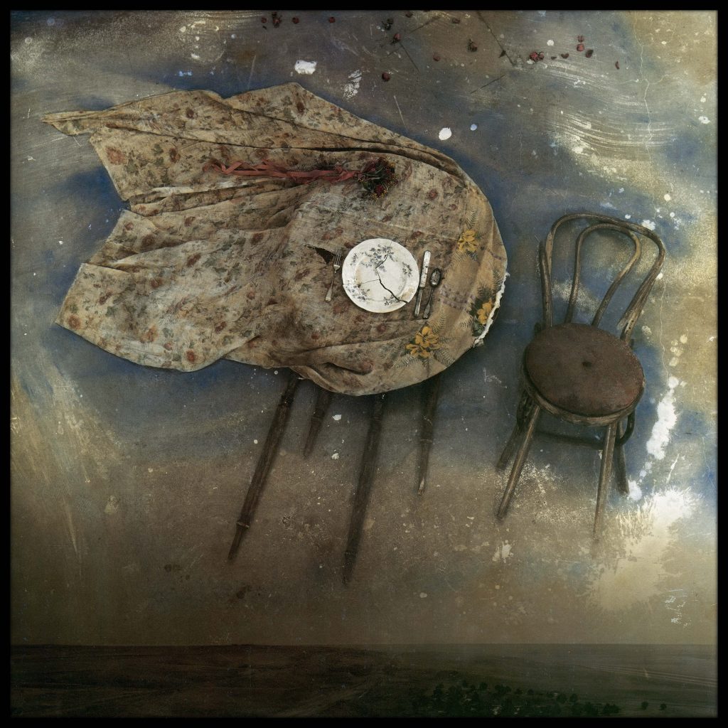 table and chair floating in sky over landscape